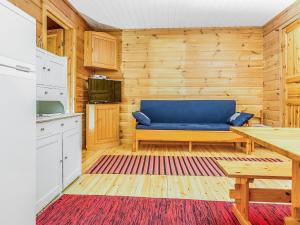a living room with a blue couch and a table at Holiday Home Ahven by Interhome in Hiukkajoki