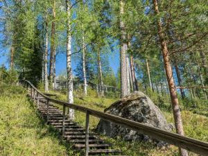 a set of stairs in a forest with a rock at Holiday Home Rantalinna 2 by Interhome in Ruokolahti
