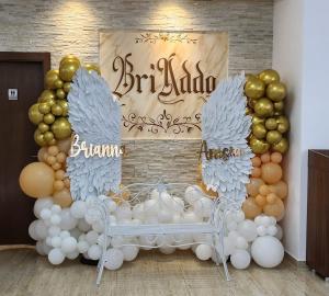 a balloon arch with a bench and a sign with wings at Pensiunea BriAdda in Poiana Mărului