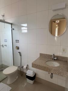 a bathroom with a toilet and a sink and a mirror at Hotel Executive Uberaba in Uberaba +28 photos