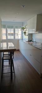 a kitchen with white cabinets and a wooden table at Apartamento en Huesca capital in Huesca