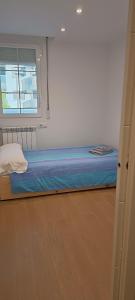 a small bed in a room with a window at Apartamento en Huesca capital in Huesca