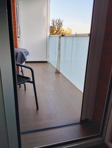 a room with a chair and a view of a balcony at Apartamento en Huesca capital in Huesca