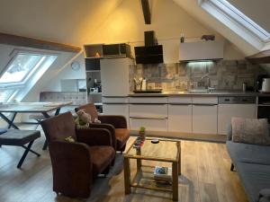 a kitchen and a living room with chairs and a table at Happy Hippo Haus in Mürlenbach