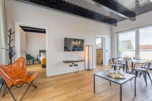 a living room with a table and chairs at LÜTTES LOFT Boutique Hotel in Eckernförde