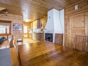 a dining room with a wooden table and a kitchen at Holiday Home Lehtotuvat e by Interhome in Kotila