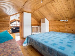 a bedroom with a bed in a wooden room at Holiday Home Lehtotuvat e by Interhome in Kotila
