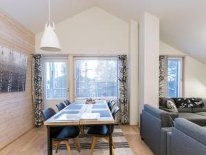 a dining room with a table and chairs and a couch at Holiday Home Levin stara a09 by Interhome in Levi