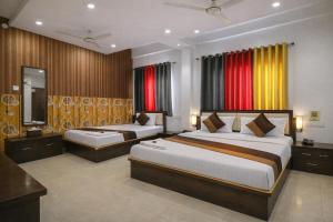 a hotel room with two beds and a television at Hotel Aarav 94 in Indore