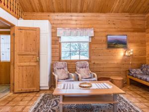 a living room with two chairs and a table at Holiday Home Lomapesä 10a by Interhome in Kotila