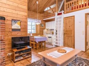 a living room with a television and a dining room at Holiday Home Lomapesä 10a by Interhome in Kotila