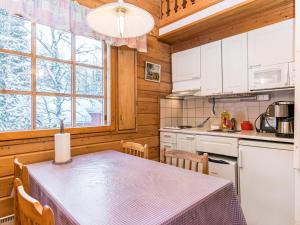 a dining room with a table and a kitchen at Holiday Home Lomapesä 10a by Interhome in Kotila