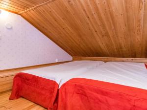 a bed in a room with a wooden ceiling at Holiday Home Lomapesä 10a by Interhome in Kotila +6 photos