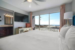 a bedroom with a large white bed and a large window at Family Tides - Beachfront Pet-Friendly Duplex in Destin