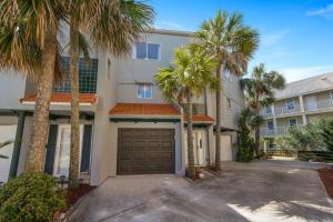 a house with palm trees and a garage at Family Tides - Beachfront Pet-Friendly Duplex in Destin
