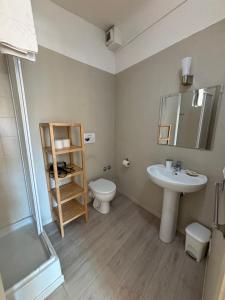 a bathroom with a sink and a toilet and a mirror at At Home Bed and Breakfast in Lucca