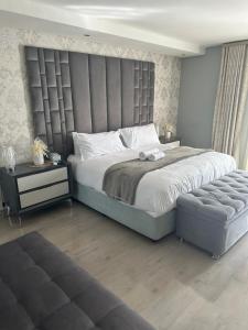a bedroom with a large bed with a large headboard at Kbros Guesthouse in Polokwane