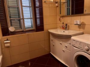 a bathroom with a sink and a washing machine at Miramare Seaside Aparts in Kotor +48 photos
