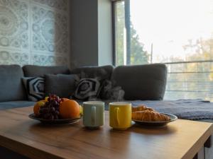 a coffee table with plates of fruit and two cups at Pikk 45 in Otepää