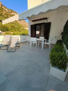 a patio with chairs and tables on a building at 80062 Cute House in Meta