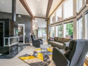 a living room with a couch and chairs and a fireplace at Holiday Home Nummentähti by Interhome in Tammela