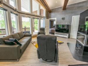 a living room with a couch and a television at Holiday Home Nummentähti by Interhome in Tammela +14 photos