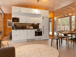 a kitchen with white cabinets and a dining room with a table at Holiday Home Solokoto by Interhome in Inari +14 photos