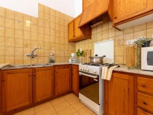 a kitchen with wooden cabinets and a stove top oven at Holiday Home D1 by Interhome in Deltebre