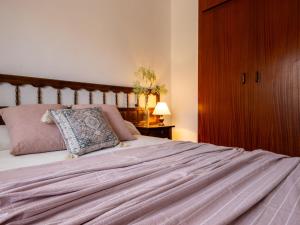 a bedroom with a large bed with a wooden headboard at Holiday Home D1 by Interhome in Deltebre