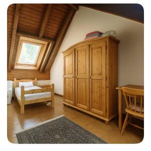 a bedroom with a large wooden cabinet and a table at SkiLift Tarvisio Apartment Free Parking in Tarvisio