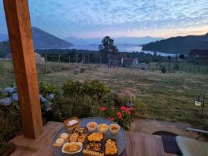 a tray of food on a table with a view of a field at Casa Bella Vista Futrono in Futrono