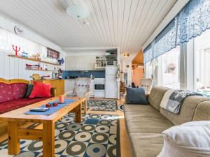 a living room with a couch and a table at Holiday Home Kivirinne by Interhome in Äijälä