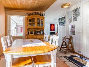 a dining room with a wooden table and chairs at Holiday Home Kivirinne by Interhome in Äijälä +16 photos