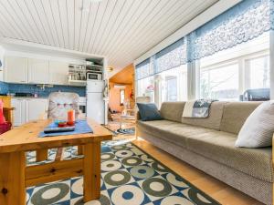 a living room with a couch and a table at Holiday Home Kivirinne by Interhome in Äijälä