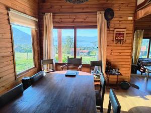 a dining room with a large wooden table and chairs at Casa Bella Vista Futrono in Futrono +11 photos