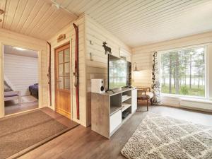 a living room with a tv and a large window at Holiday Home Jormakka by Interhome in Levi +10 photos