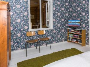 a room with two chairs and a mirror and a tv at Holiday Home Hiljanrinne by Interhome in Haminankylä +8 photos