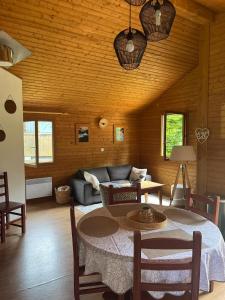 a living room with a table and a couch at CHALET Cosy in Uxelles +17 photos