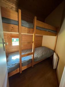 a bedroom with two bunk beds in a cabin at CHALET Cosy in Uxelles
