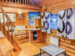 a log cabin living room with a staircase and a desk at Holiday Home Lumomarja by Interhome in Pyhätunturi