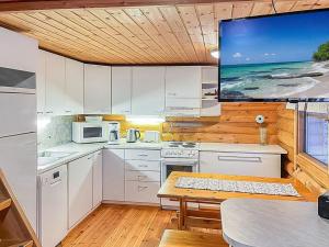 a kitchen with white cabinets and a flat screen tv at Holiday Home Lumomarja by Interhome in Pyhätunturi