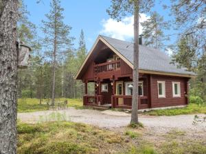 a log cabin in the woods with a tree at Holiday Home Kätkä by Interhome in Kotkasuvanto