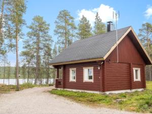 a small wooden cabin with a black roof at Holiday Home Kätkä by Interhome in Kotkasuvanto