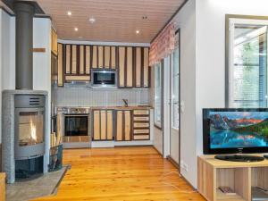 a kitchen with a fireplace and a tv in a room at Holiday Home Pulkka 1 by Interhome in Salla