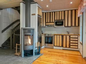 a kitchen with a fireplace in the middle of a room at Holiday Home Pulkka 1 by Interhome in Salla +16 photos