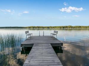 two chairs sitting on a dock on a lake at Holiday Home Torniniemi by Interhome in Hiukkajoki