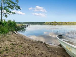 a boat sitting on the shore of a lake at Holiday Home Torniniemi by Interhome in Hiukkajoki
