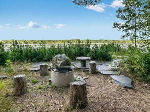 a park with a picnic table and tree stumps at Holiday Home Torniniemi by Interhome in Hiukkajoki