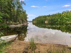 a boat sitting on the shore of a lake at Holiday Home Lahukka by Interhome in Hurissalo