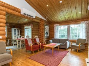 a living room with wooden walls and a wooden ceiling at Holiday Home Lahukka by Interhome in Hurissalo +23 photos